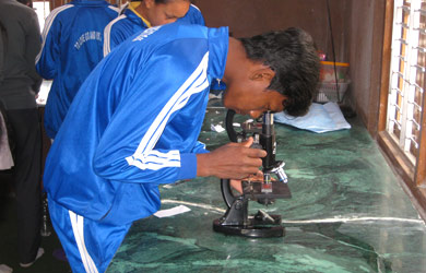 Nepali student using laboratory microscope